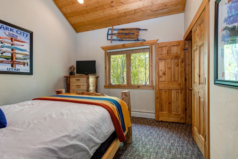 The second guest room features a Queen bed and warm wood finishes, perfect for couples or solo travelers. TWL-5B