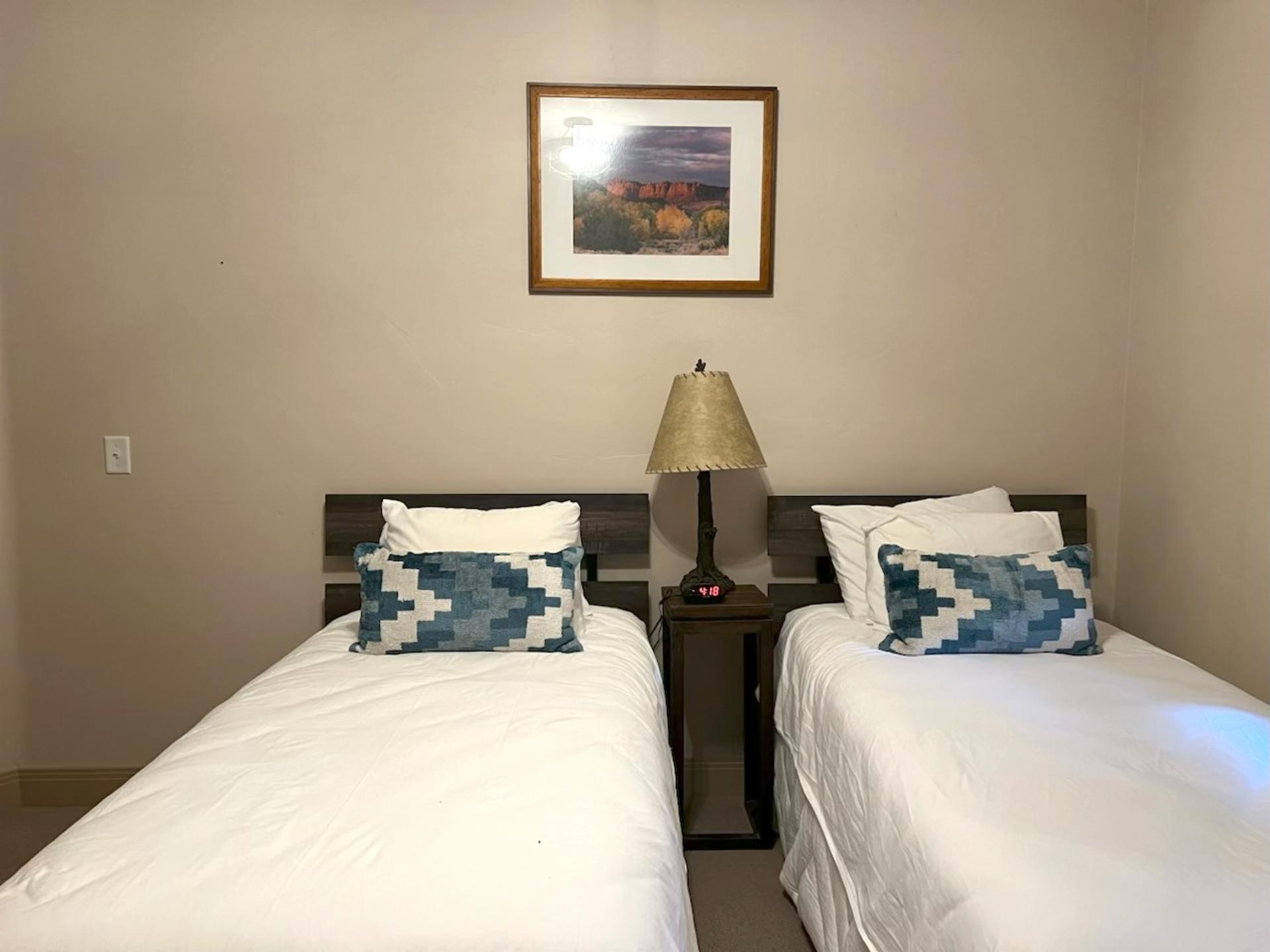 This quiet guest room features two Twin beds and soft lighting. Perfect for kids, friends, or flexible sleeping arrangements.