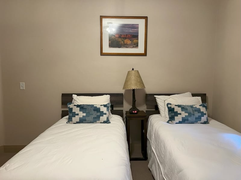 This guest room features two Twin beds and soft lighting. Perfect for kids, friends, or flexible sleeping arrangements.