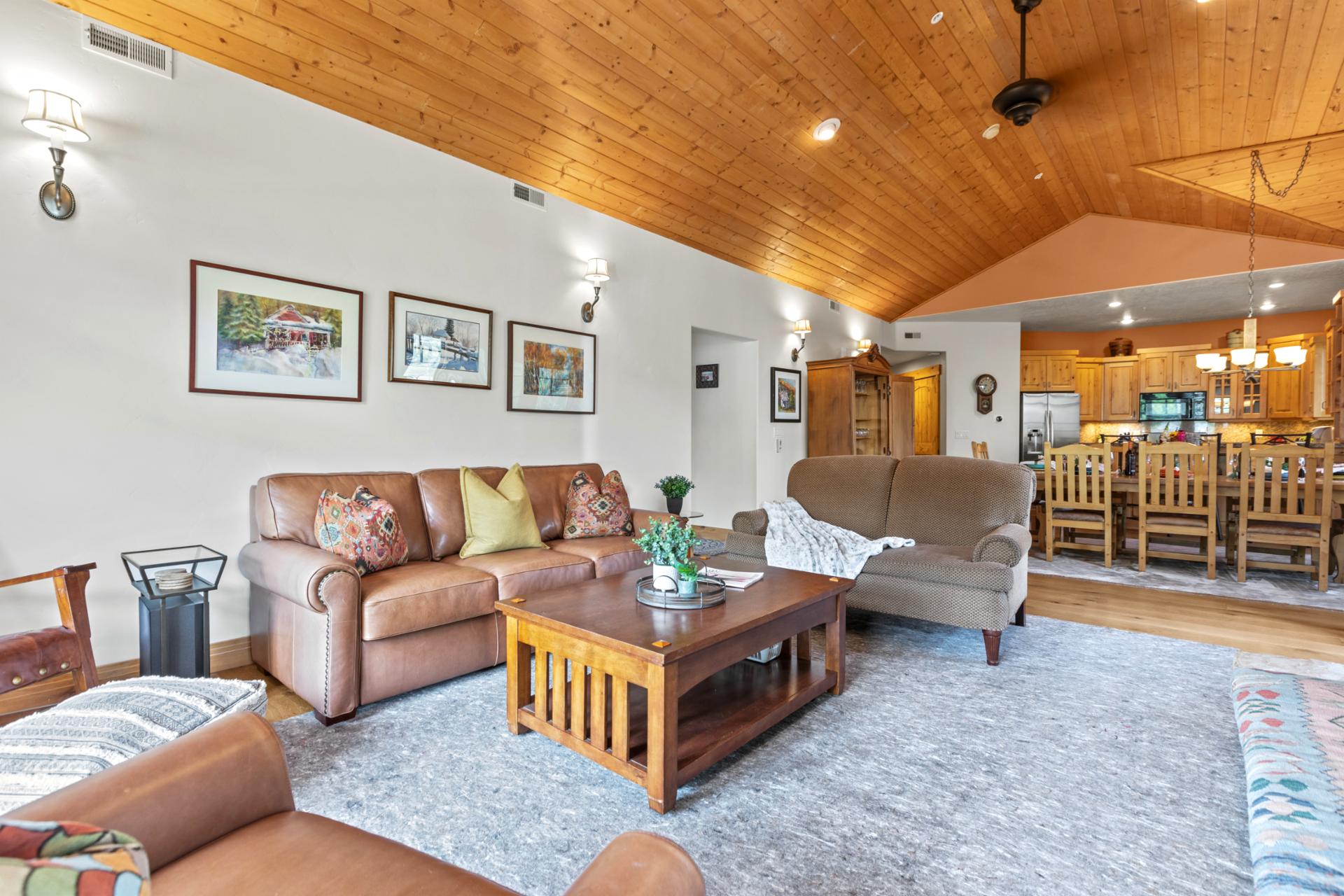 Vaulted ceilings and wood beams frame your cozy living area and dining room beyond.