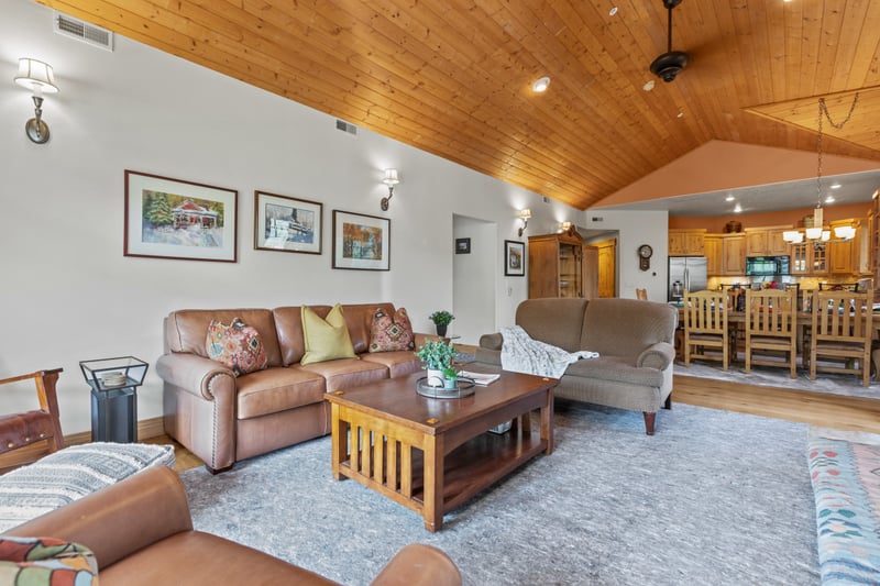 Vaulted ceilings and wood beams frame your cozy living area and dining room beyond.