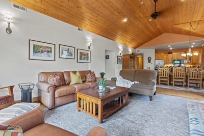 Vaulted ceilings and wood beams frame your cozy living area and dining room beyond.