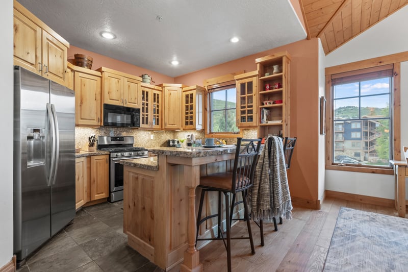 Alternate kitchen view highlights the island bar and open layout into the dining area.