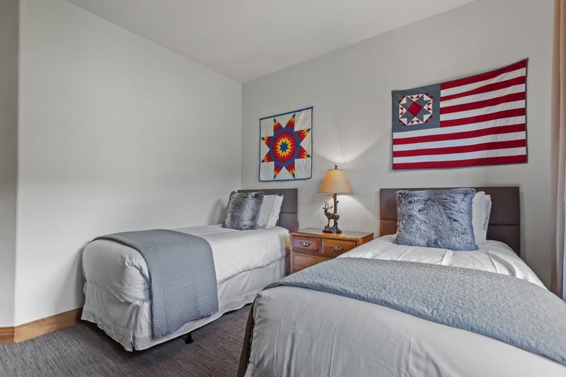Twin layout with forest views and a bright, airy feel.