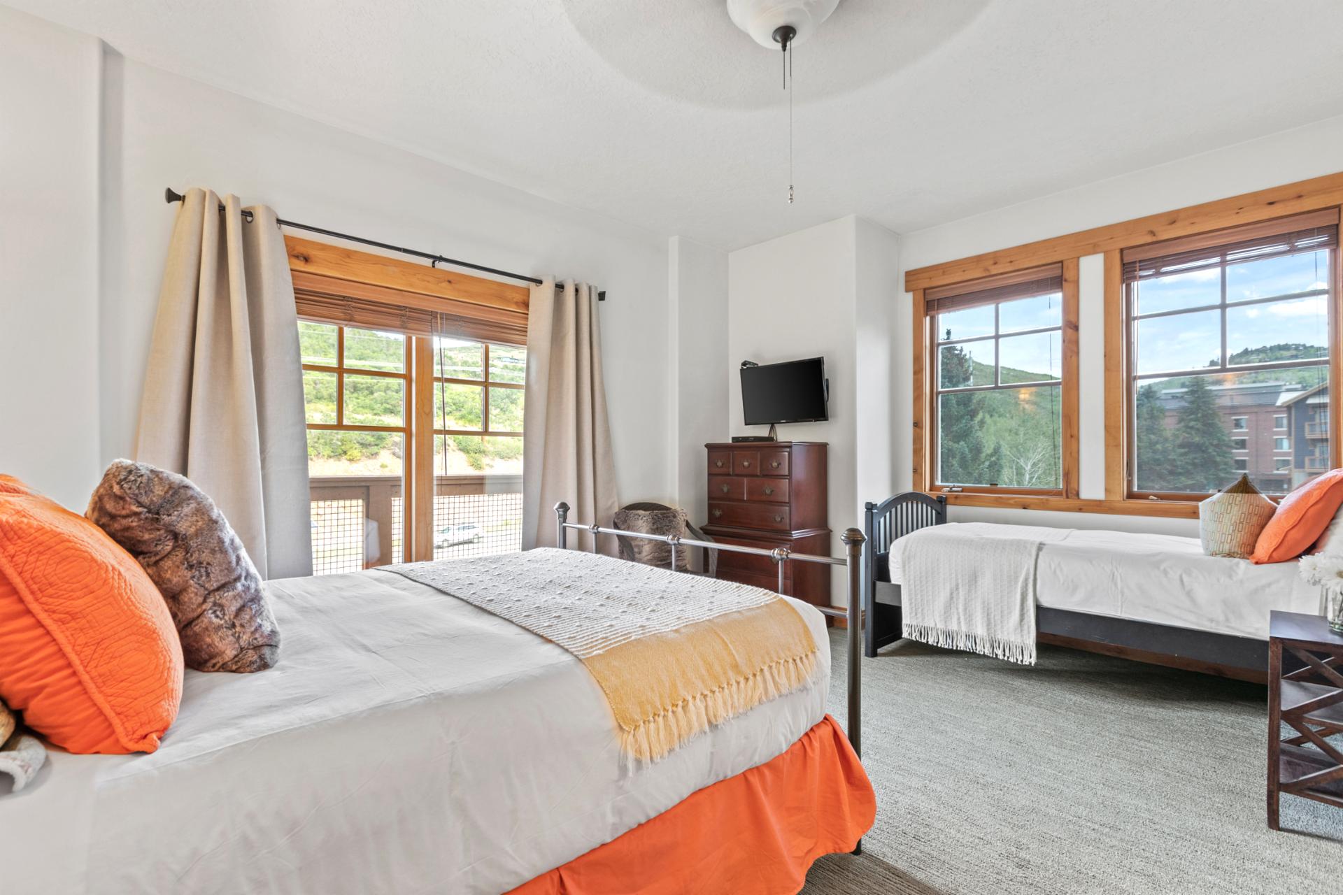 Second view of Bedroom 2 with bright windows and mountain-inspired design.