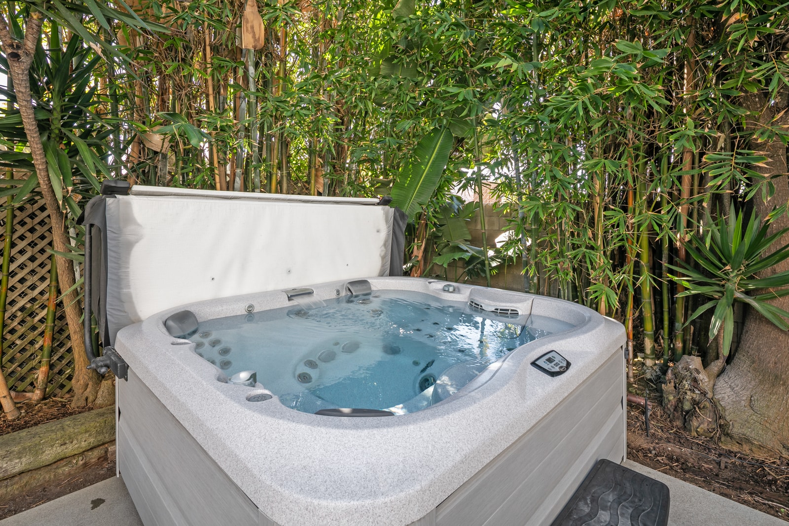 The hot tub sits within lush landscaping, giving you a private spa like experience at home.
