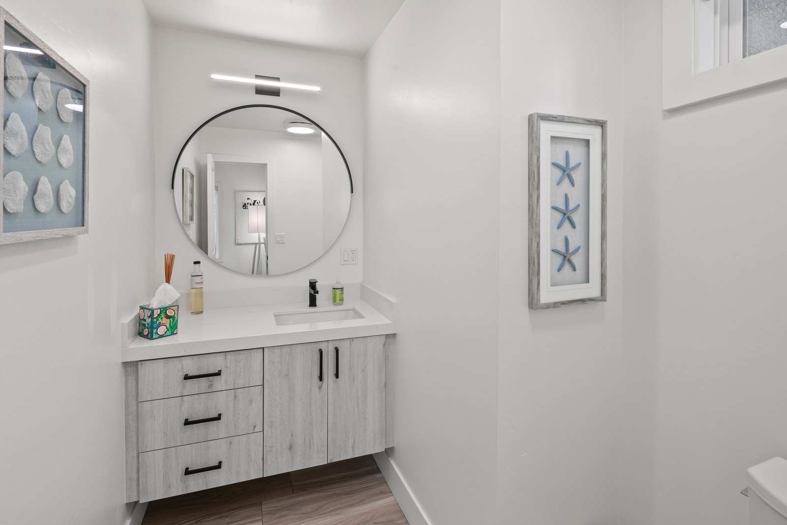 The second guest bathroom features bright finishes and a practical setup, making shared living easy.
