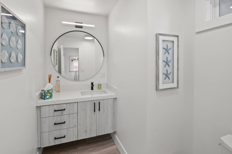 The second guest bathroom features bright finishes and a practical setup, making shared living easy.