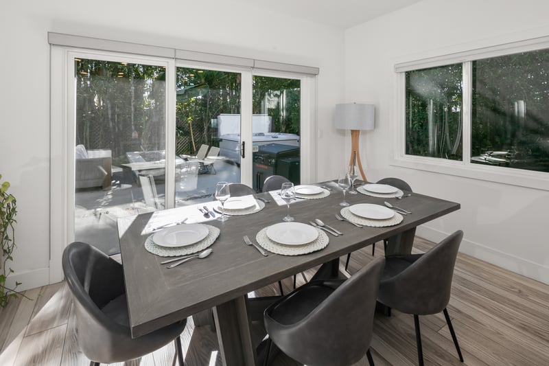 Host casual dinners at the long dining table, where backyard views keep the room feeling bright and comfortable.