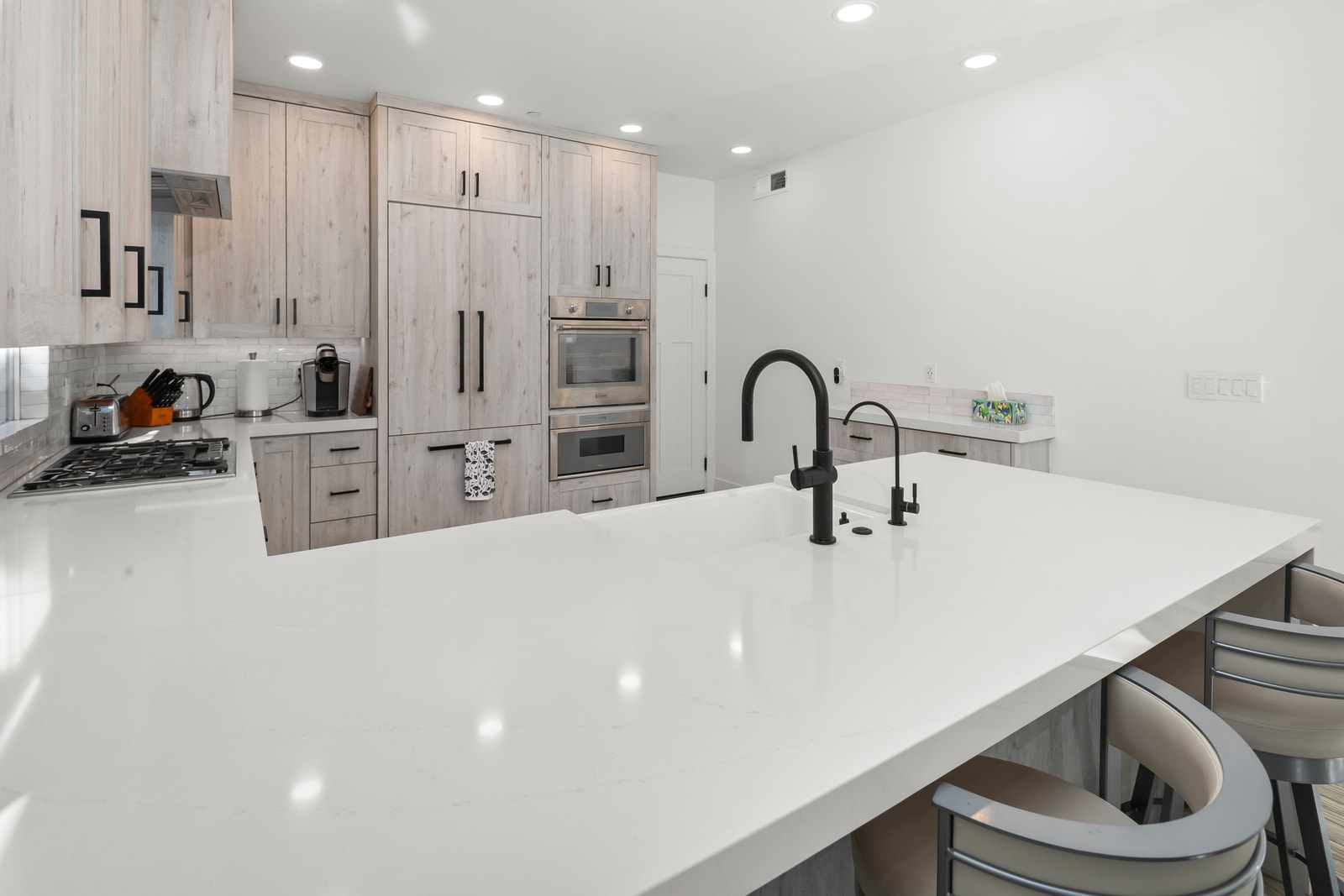 The spacious island supports chopping, snacking, and conversation, with ample lighting for comfortable evening cooking sessions.