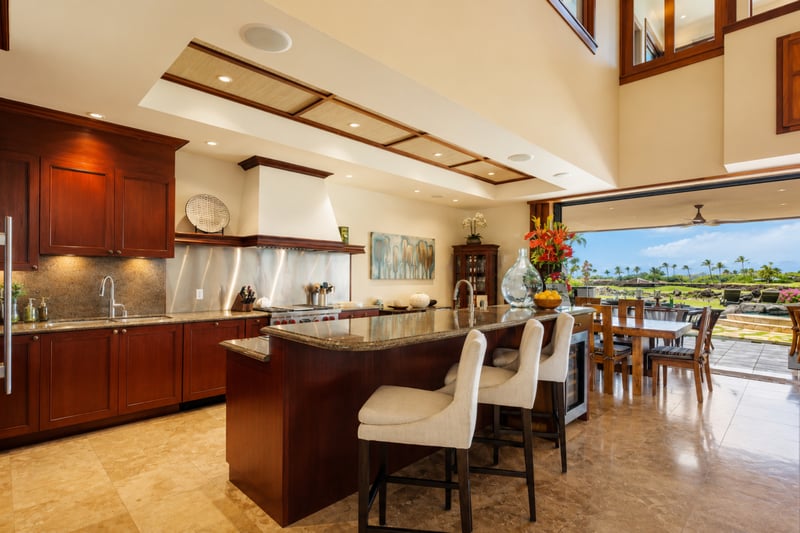 The kitchen features warm wood cabinetry, dark countertops, and a breakfast bar with seating