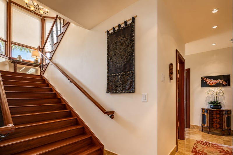 Wide, natural wood stairs take you upstairs to the primary bedroom