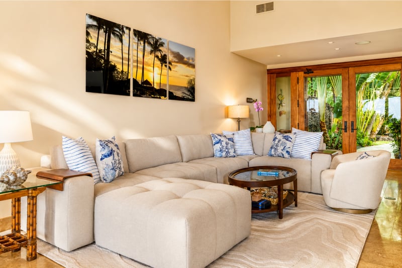 A second view of the living room shows comfortable seating and rich wood furnishings
