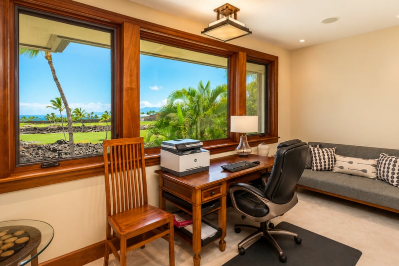 The den features a comfortable seating area in addition to the private workspace