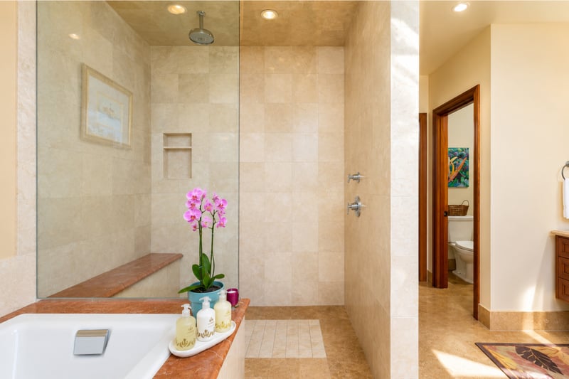Stone tile and warm wood finishes give the primary bath a spa-like feel