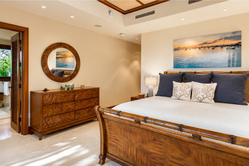 The spacious downstairs bedroom features warm, real wood furnishings and tasteful island inspired decor
