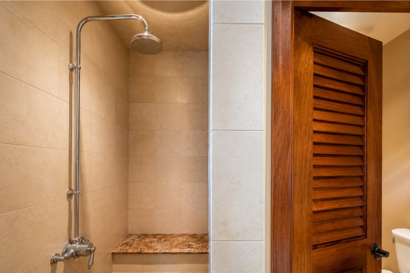 The guest bathroom features a spacious walk in shower with a granite bench