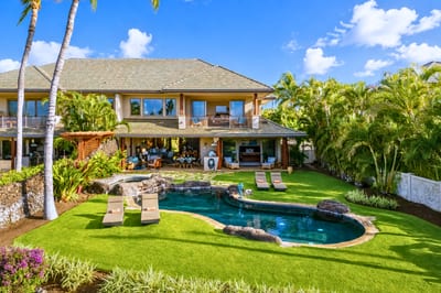 An aerial view captures the perfectly maintained lawn and pool area