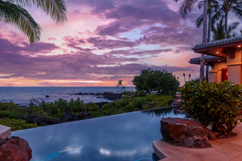Swim in your private infinity-edge pool overlooking the ocean and surrounded by sunset skies.