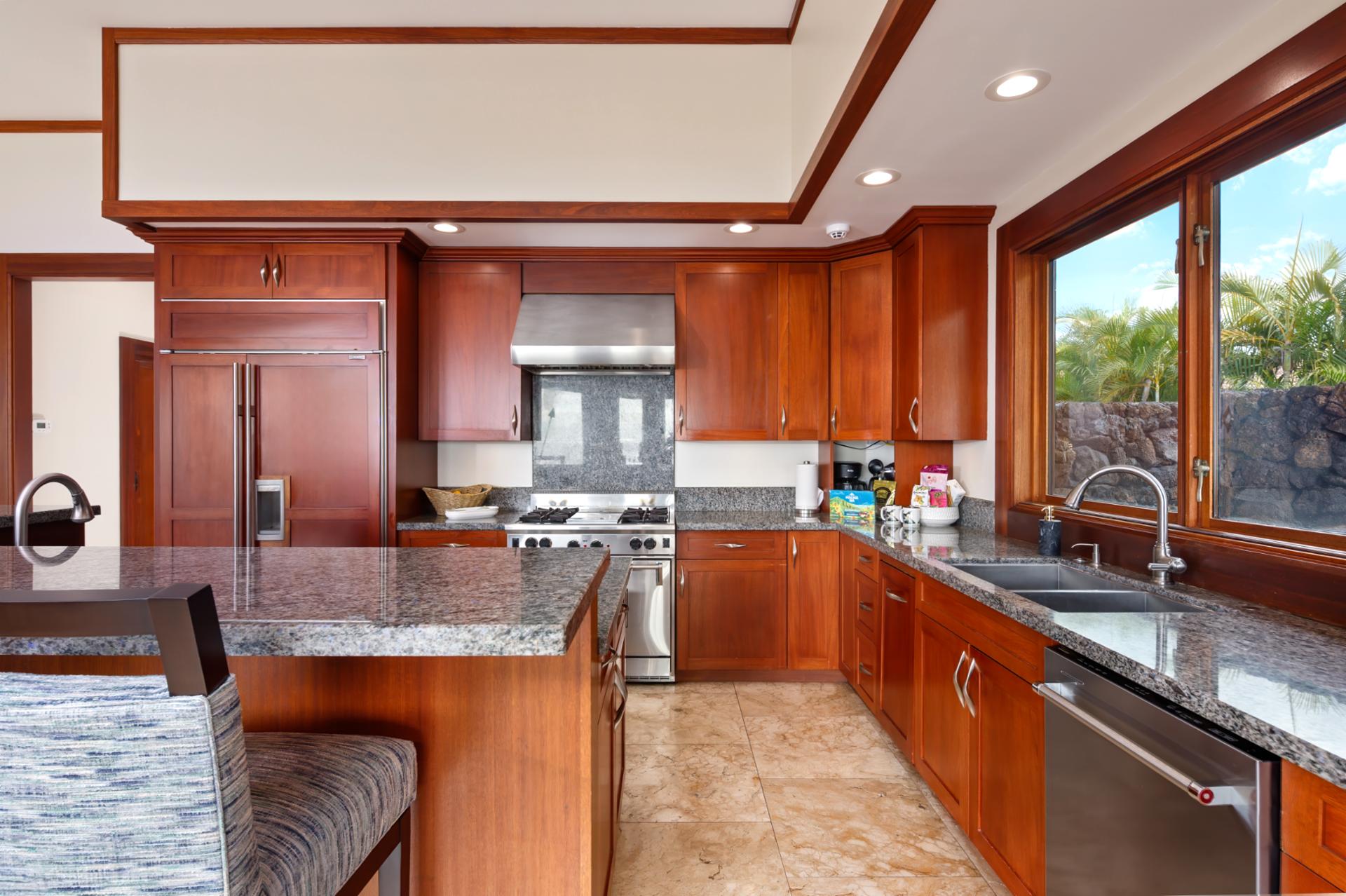 Fully equipped kitchen includes double ovens, full-size fridge, and expansive counter space.