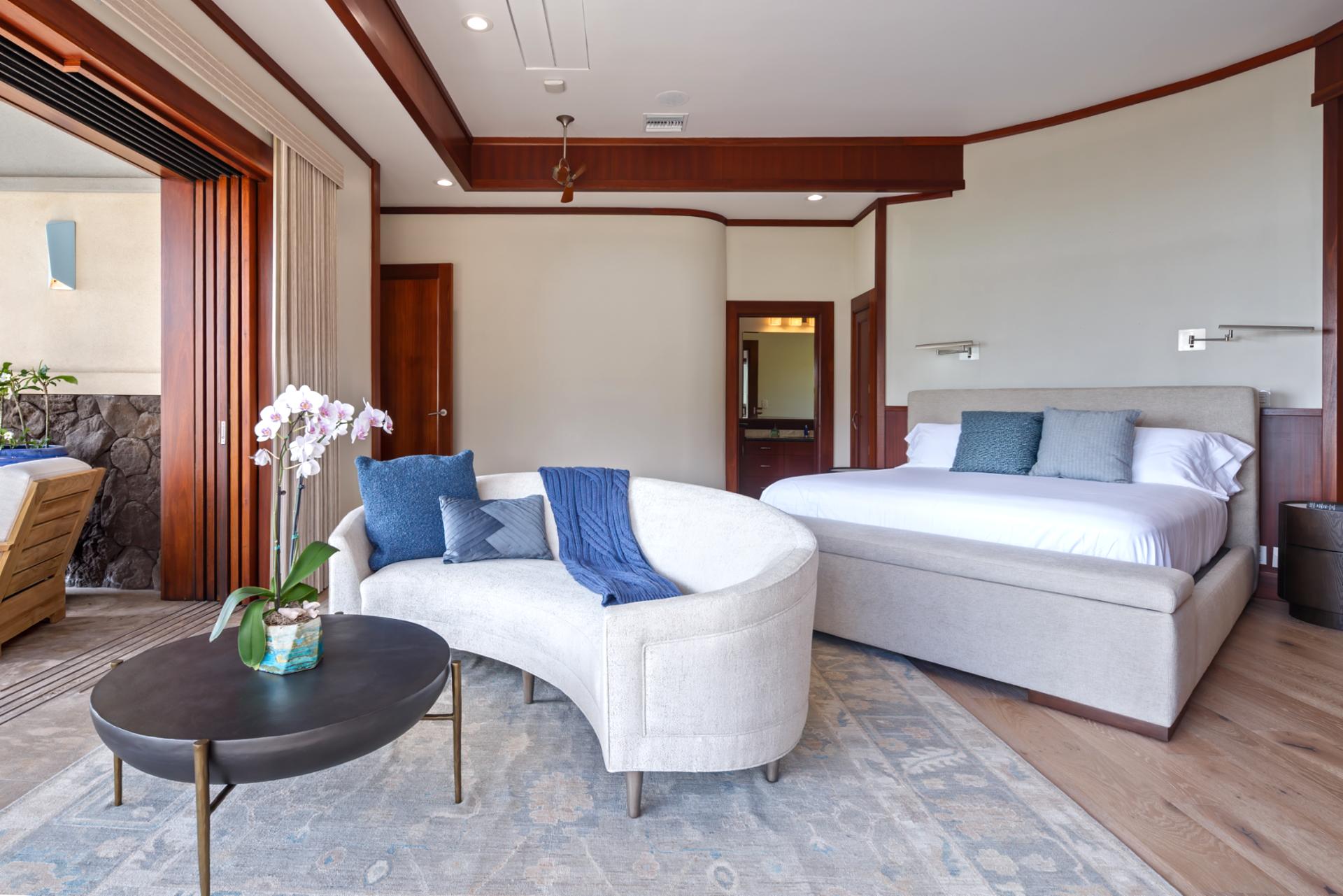 Unwind in the spacious primary bedroom with garden views and lounge seating.