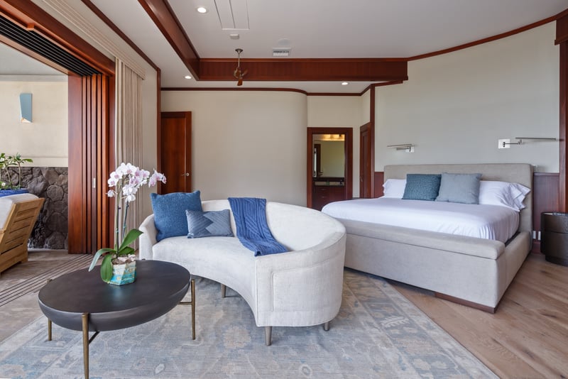 Unwind in the spacious primary bedroom with garden views and lounge seating.