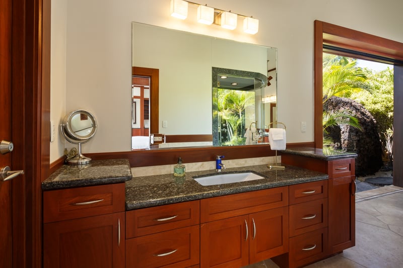 Your ensuite bath features dual vanities, warm wood cabinetry, and plenty of natural light.