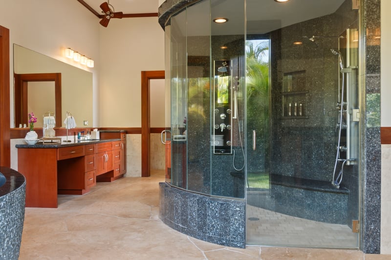 Indulge in spa-like luxury in the master bath featuring a stunning glass-enclosed walk-in shower with multiple rain heads, body jets, and a sleek granite finish. Your private oasis of relaxation.
