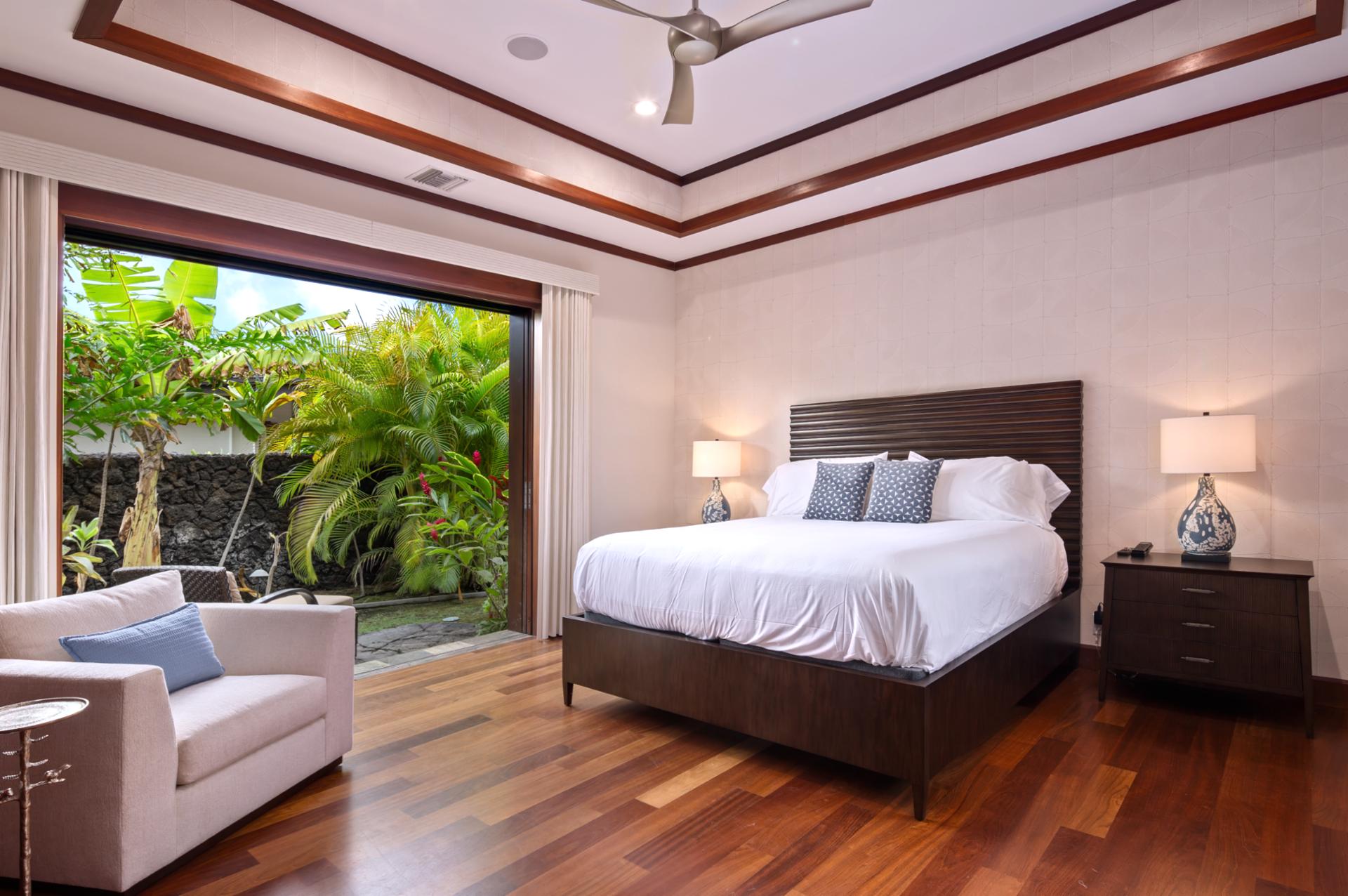Guest bedroom includes a King bed, wood-paneled ceiling, and garden-facing windows.