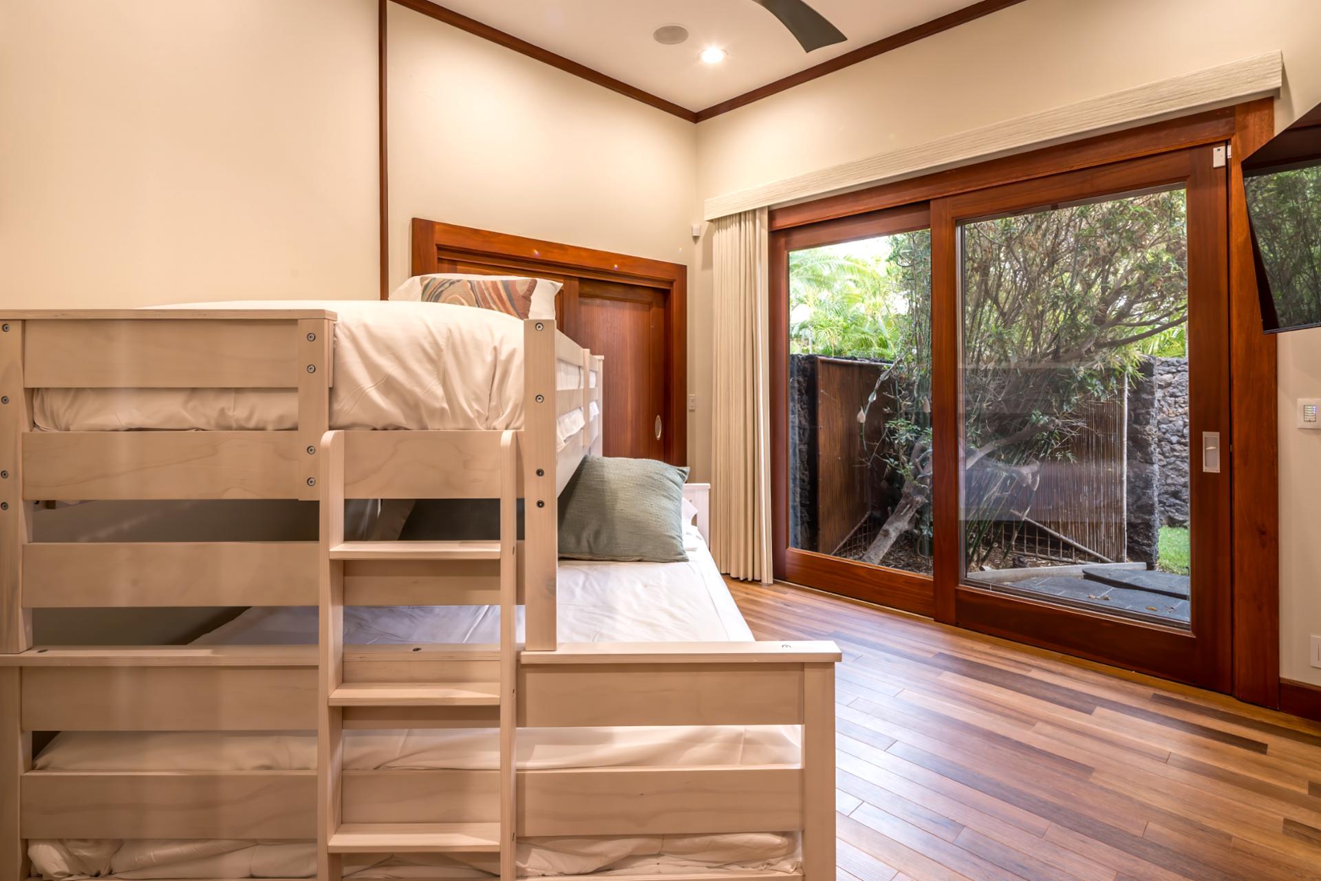 Spacious bunk-style room includes a TV, storage, and room for both kids and adults.