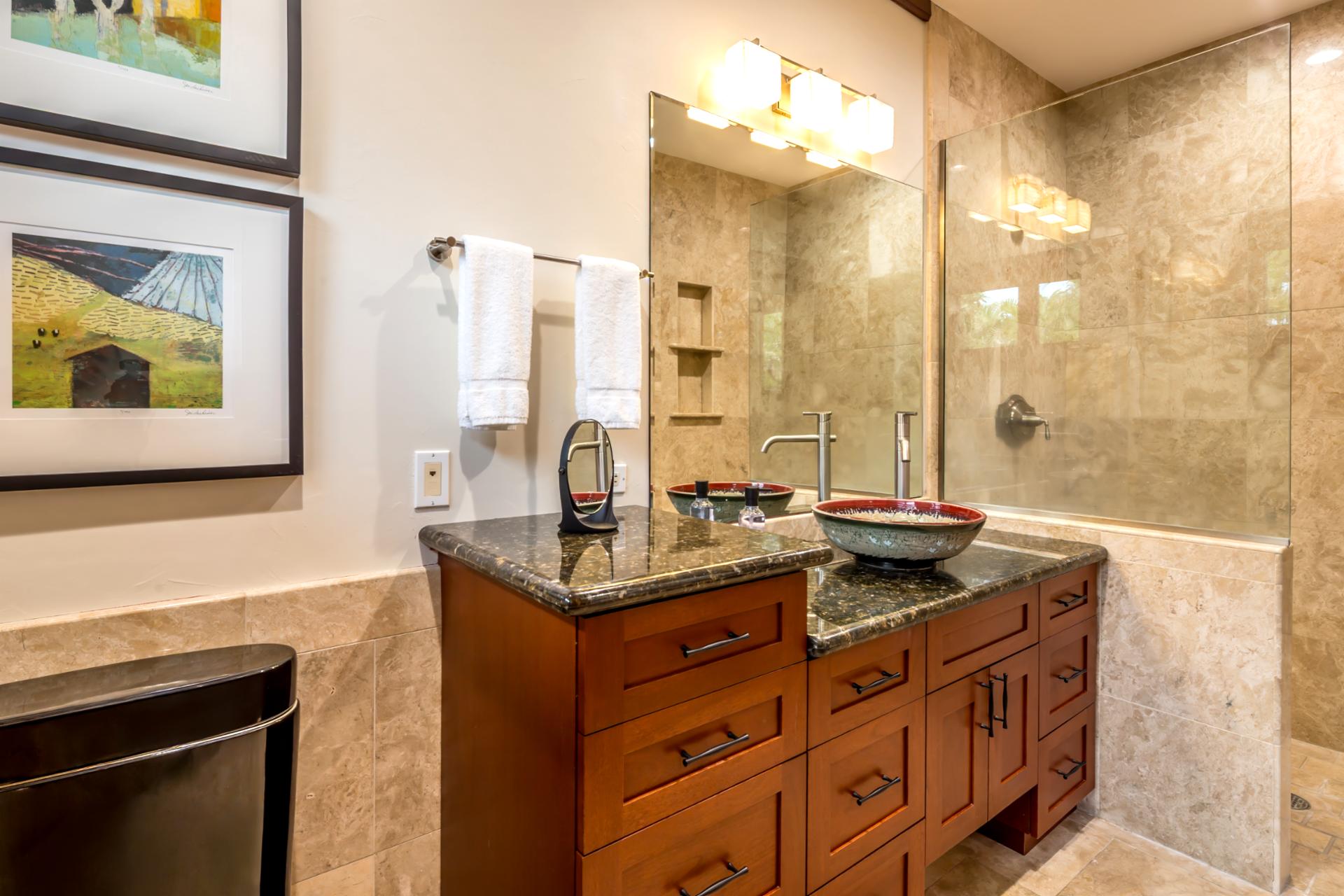 Elegant guest bath features full amenities, stylish lighting, and tile detail.