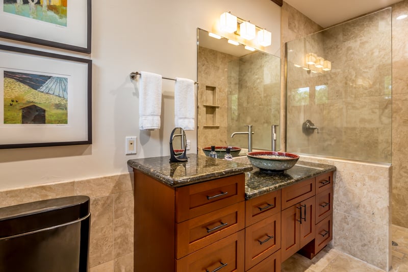 Elegant guest bath features full amenities, stylish lighting, and tile detail.