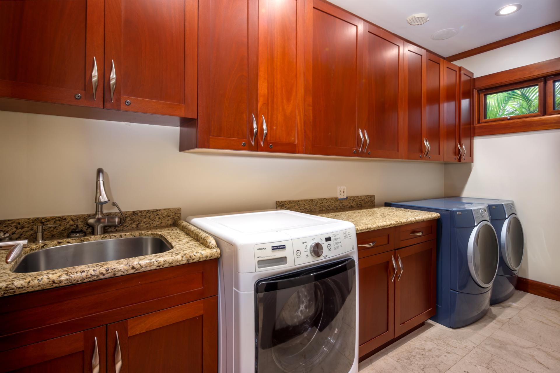 Laundry room includes washer, dryer, deep sink, and storage for longer stays.