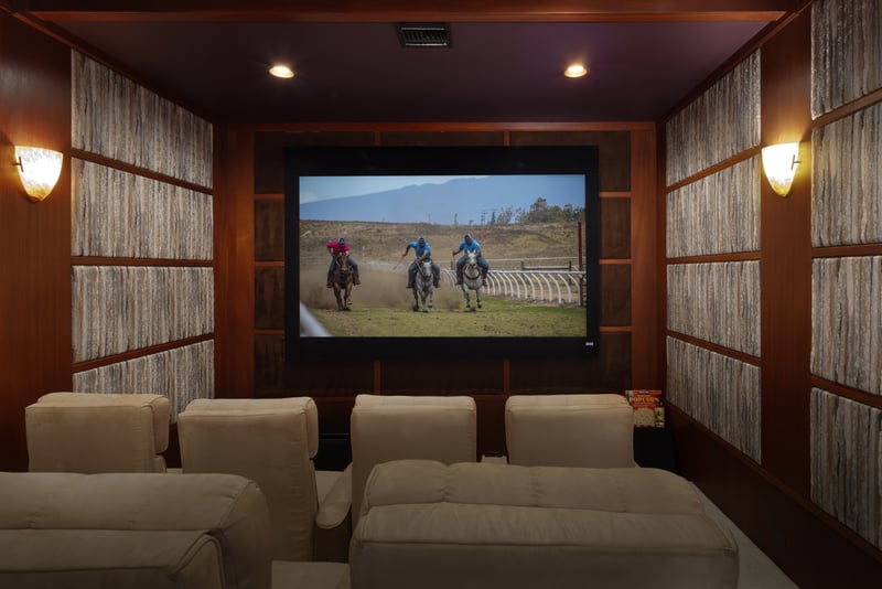 Theater room with a projector and lounge seating is perfect for movie nights in.