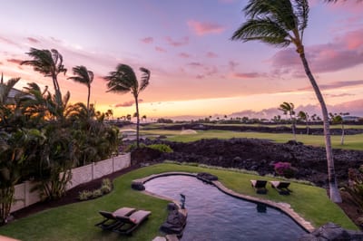 The pool glows at dusk as the sky shifts to deep pink and violet