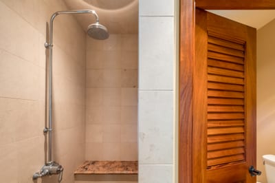 The guest bathroom features a spacious walk in shower with a granite bench