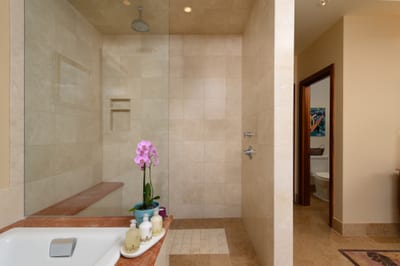 Stone tile and warm wood finishes give the primary bath a spa-like feel