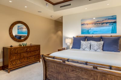 The spacious downstairs bedroom features warm, real wood furnishings and tasteful island inspired decor