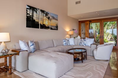 A second view of the living room shows comfortable seating and rich wood furnishings
