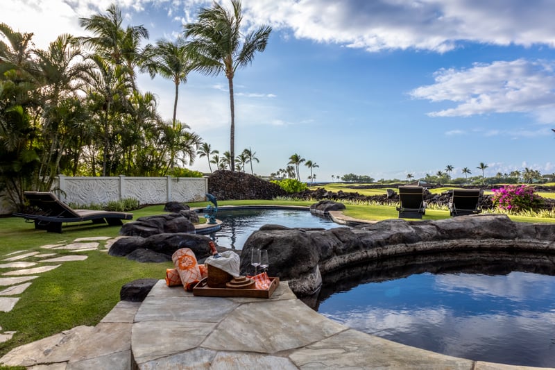 The resort-style private pool is framed by palm trees, making it the perfect place to relax