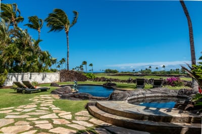 Stone pathways wind through the lush yard, taking you directly to the pool