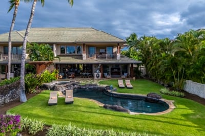 An aerial view captures the perfectly maintained lawn and pool area