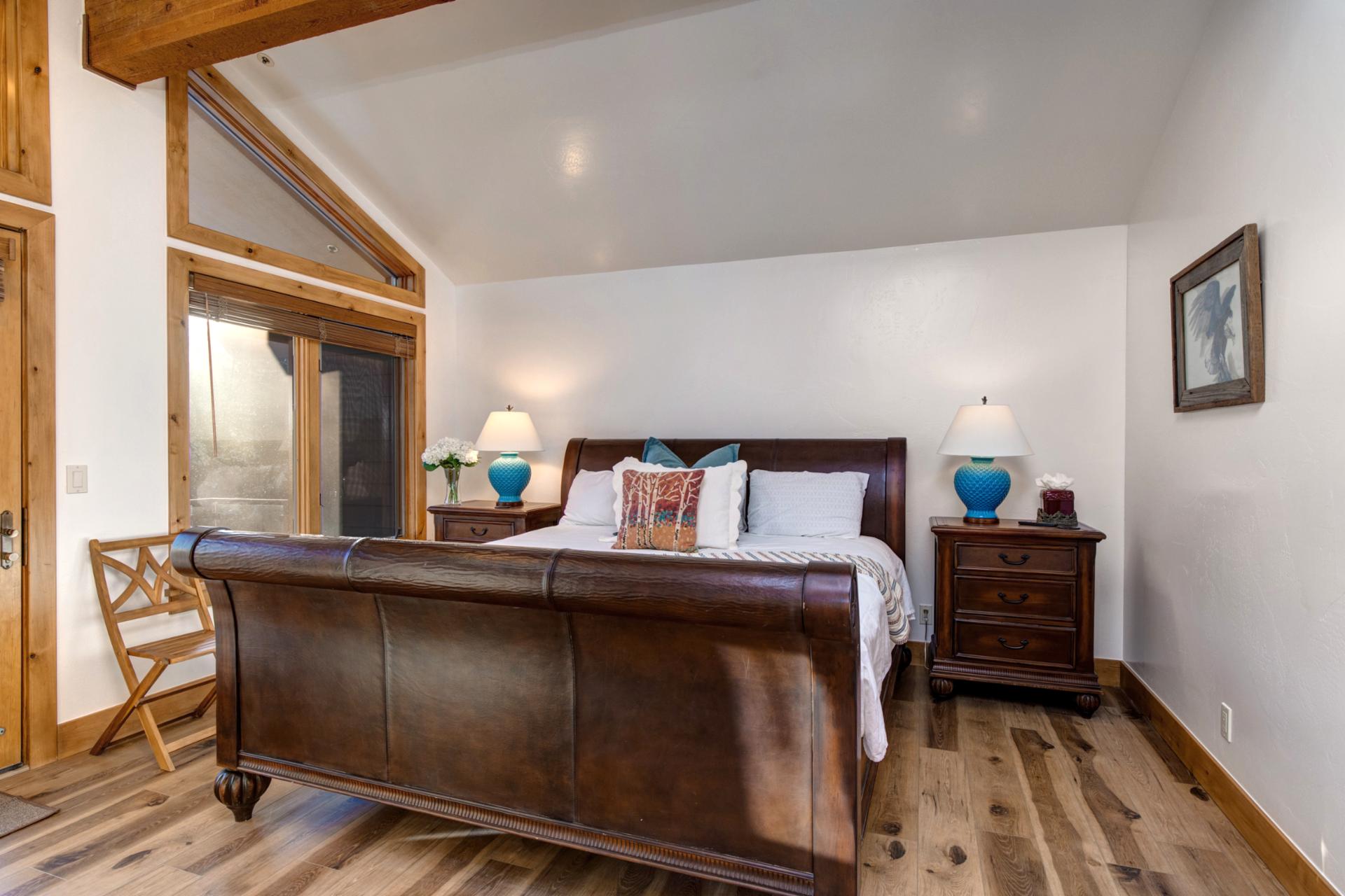 Warm wooden floors, a king-size bed, TV, and a cozy gas fireplace—comfort and style in one inviting space