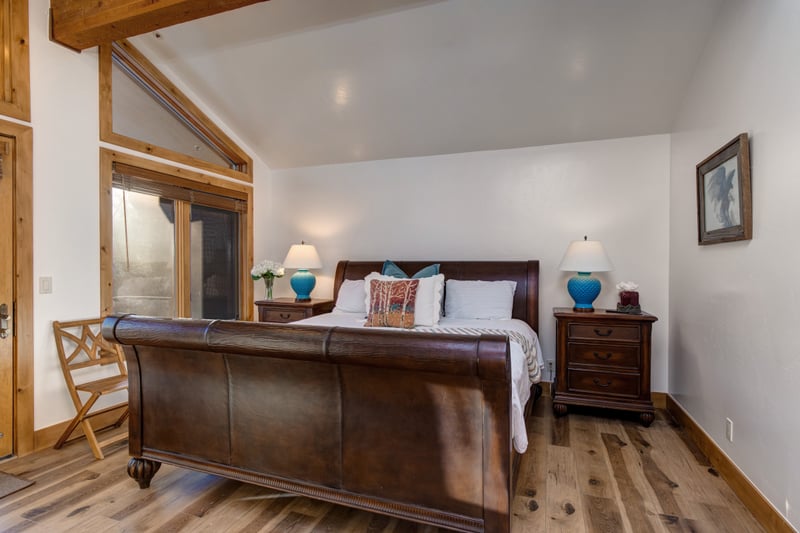 Warm wooden floors, a king-size bed, TV, and a cozy gas fireplace—comfort and style in one inviting space