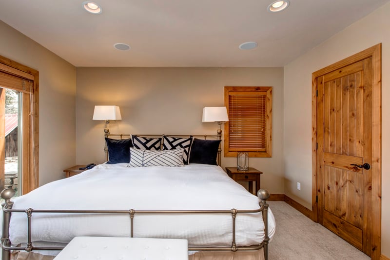 The downstairs King suite offers privacy and comfort with natural light and warm wood tones.