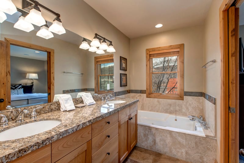 Primary ensuite bath includes a soaking tub, walk-in shower, and dual granite vanities