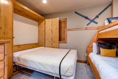 Cozy bunk room with pull-out bed and charming rustic wood decor.
