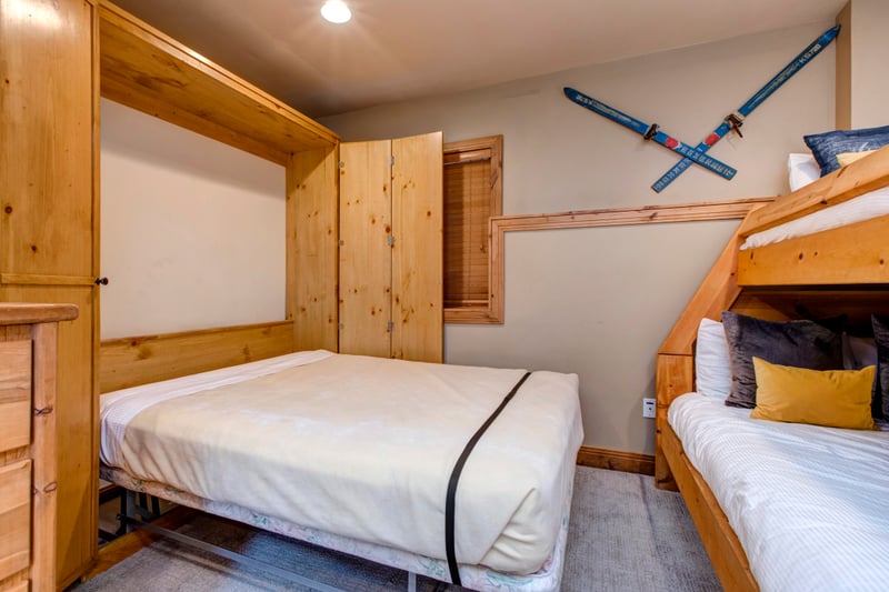 Cozy bunk room with pull-out bed and charming rustic wood decor.