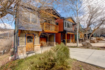 Charming neighborhood houses with vibrant colors and scenic mountain backdrop.