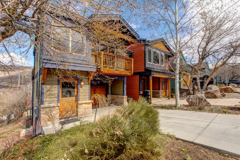 Charming neighborhood houses with vibrant colors and scenic mountain backdrop.